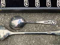 Close-up of spoon handles showing EPNS hallmarks and pierced design