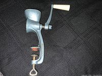 Clamp-on blue-grey metal hand meat grinder marked Ideal