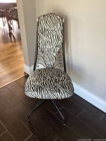 Front view showing zebra upholstery, high back, metal frame