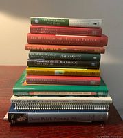 Stack of 12 golf books on table