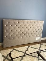 Front view of grey tufted velour king headboard