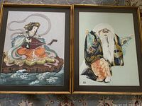 Both framed embroideries side by side showing subjects and frames