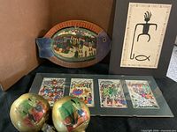 Overview of maracas, fish plate, matted prints and framed figure print