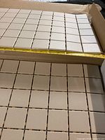 Box showing bone-colour ceramic mosaic sheets with tape measure indicating sheet size