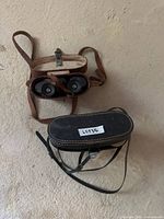 Top view of both binoculars inside their cases showing straps and eyepieces