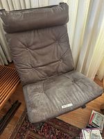 Front view of leather lounge chair showing cushion and dust