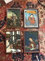Front view of all four framed pictures laid out on rug