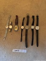Overall shot of seven wristwatches laid out on carpet