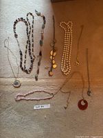 All eight necklaces laid out on carpet