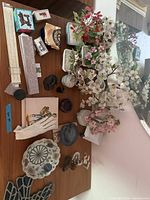 Overview of all items on tabletop including bonsai trees, slide rule, plate, trivet, containers and trinkets