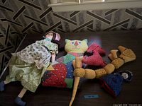 Overview of all fabric dolls and toys on table