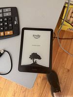 Kindle Paperwhite on startup tree screen with accessories nearby