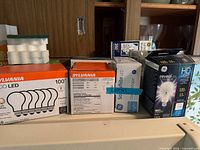 Multiple boxed light bulbs from Sylvania, GE and others on shelf
