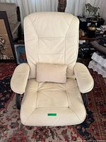 Front view showing off-white leather chair, cushioned seat/back and armrests, lumbar pillow