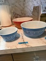 Front view of three nesting Pyrex bowls showing colours and pattern