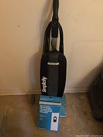 Front view of Simplicity upright vacuum with bag box placed on base