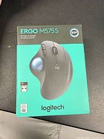 Front of sealed retail box showing Logitech ERGO M575S image and features