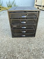 Front view of black metal mesh organizer showing five drawers