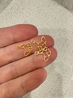 three charms resting on fingers showing size and design