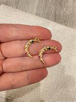 Front view of both gold-tone crescent moon pendants showing colored rhinestones