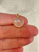 Pendant held between fingers showing size, stone and bail