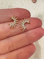 Front view of both gold plated cubic zirconia pendants on fingertip