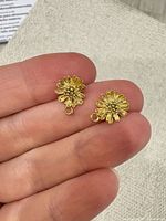 Both small gold daisy charms resting on fingertips showing size and finish