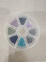 Top view of organiser wheel showing seven compartments filled with assorted beads