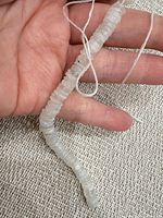 Strand held in hand showing overall appearance and translucence