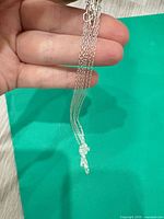 Three silver cable chains held together, showing chain style