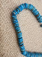 Close-up of turquoise heishi beads showing color and matrix