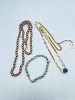 Overview of three pearl jewellery items