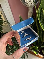 Open blue Avon box displaying three silvertone rhinestone rings in foam insert