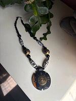 Full view of necklace laid flat showing bead sequence and pendant
