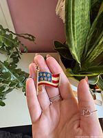 Front view of gold-tone American flag brooch showing enamel colors and design