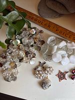 Overall lot view showing necklaces, pendants, earrings and ruler for scale