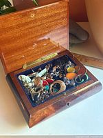 Open jewelry box showing interior velvet lining and costume jewelry contents