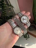 Hand holding Timex watch and two stainless bracelets