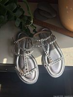 Top view of both silver rhinestone T-strap sandals