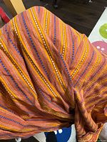 Overview of folded orange striped cotton fabric