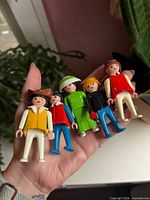 Front view of five 1974 Playmobil figures in hand