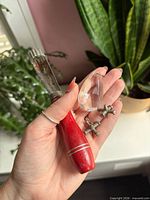 All items in hand: wood-handled tool, glass prism, two metal jacks
