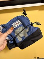 Side view of Stonz blue bootie showing logo patch, elephant applique, drawstring toggles