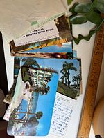 Stack of five colour postcards with resort imagery and an envelope