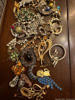 Full grouping of mixed brooches and pins on wood surface