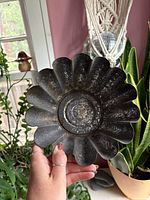 Top view of scalloped mold showing interior embossed floral pattern and dark patina