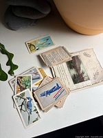 Mixed postcards and cigarette cards spread on table