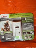 Front of sealed Kidde CO alarm packaging showing product, family image, key features