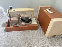 Singer model 237 sewing machine in base next to detached case lid