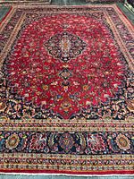 Full view of Mashhad rug showing red field and central medallion